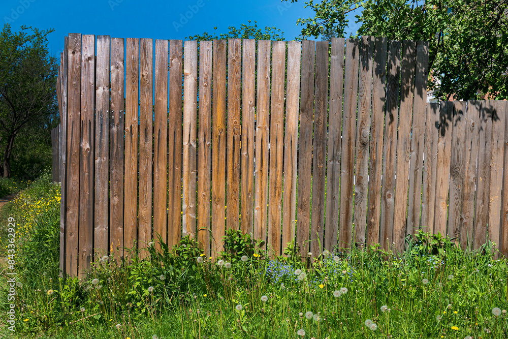 Fototapeta premium Photo of a wooden fence made of boards in a village garden.