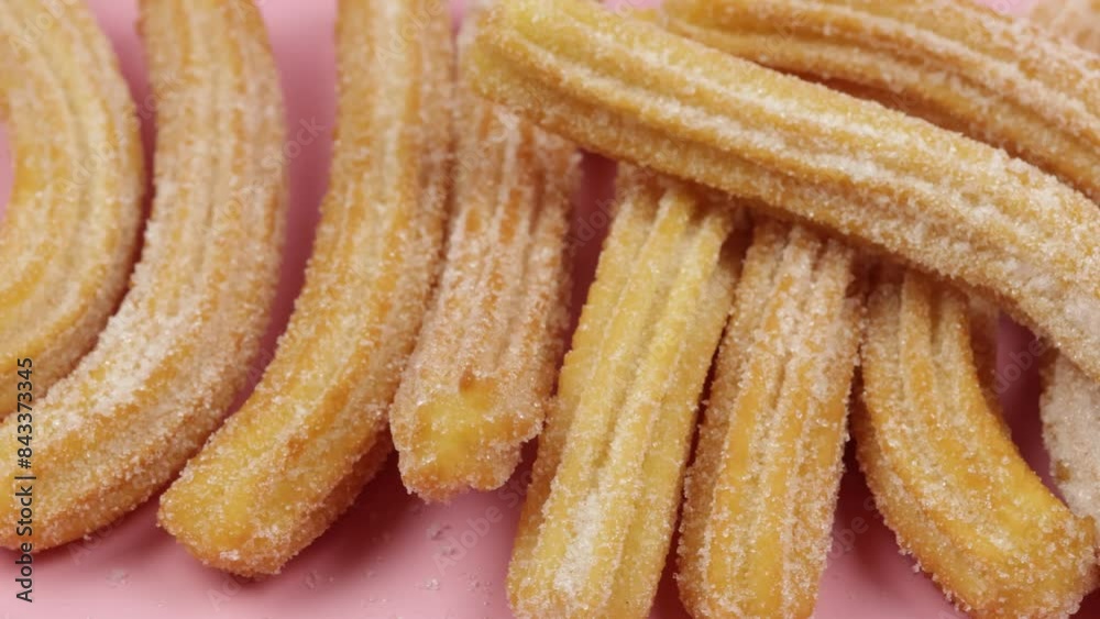 plusieurs churros, en gros plan, sur un fond rose plusieurs churros, en gros plan, sur un fond rose