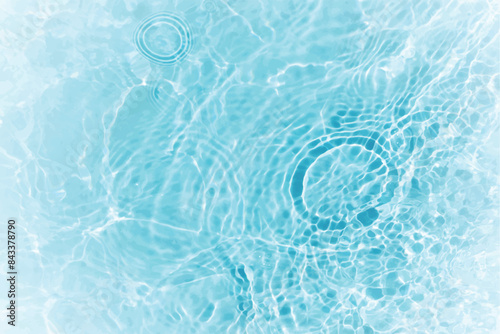 Blue water with ripples on the surface. Defocus blurred transparent blue colored clear calm water surface texture with splashes and bubbles. Water waves with shining pattern texture background.