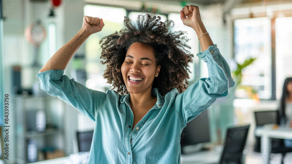 Obraz premium Excited Afro-American businesswoman at desk with hands up feel euphoric win online lottery, happy woman overjoyed get mail at laptop being promoted at work, amazed good news at computer in office