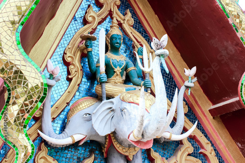 Colorful deity statue on threeheaded elephant, intricate craftsmanship and vibrant colors photo