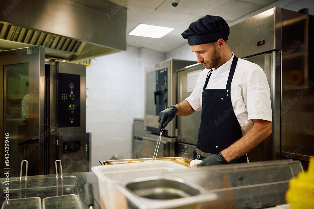 Mid adult chef preparing food in restaurant. Mid adult chef preparing food in restaurant.