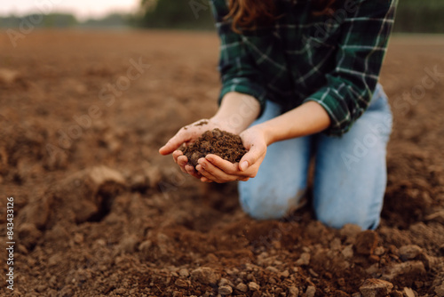 Close up of the female hands touching dry ground in an agricultural field while analyzing soil during the summer day. Business or ecology concept.