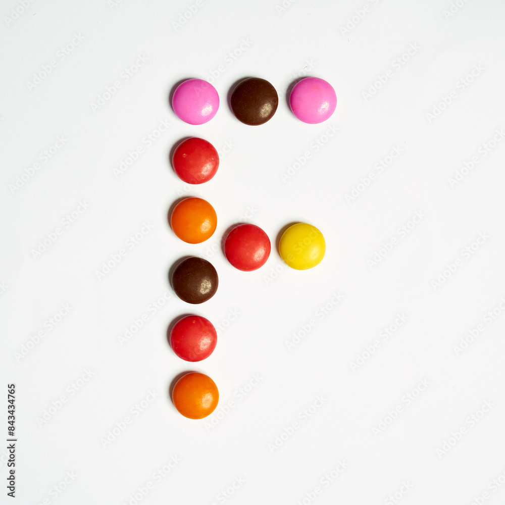 Colored chocolate coated candy alphabet on white background. F
Colored chocolate coated candy alphabet on white background. F