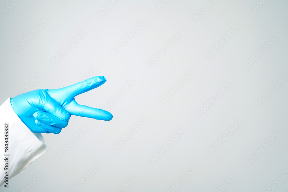 hand gestures or signs in blue disposable latex surgical gloves isolated