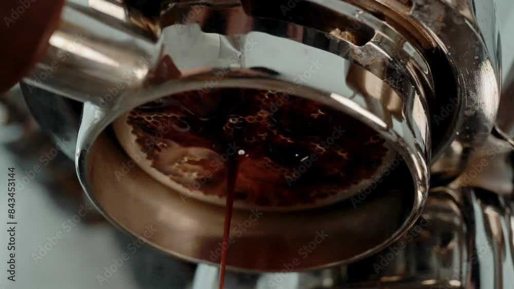 4K Pouring coffee stream from professional machine in cup. Barista man making double espresso, using filter holder. Flowing fresh ground coffee. Drinking roasted black coffee in the morning. 4K Pouring coffee stream from professional machine in cup. Barista man making double espresso, using filter holder. Flowing fresh ground coffee. Drinking roasted black coffee in the morning.