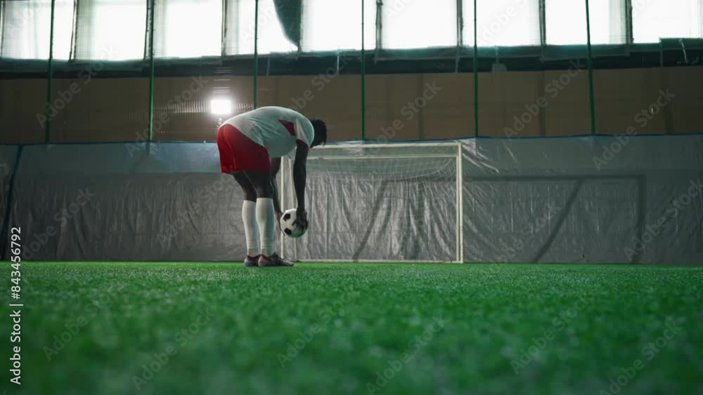 Black soccer player exercising penalty in training hall, scoring goal ...