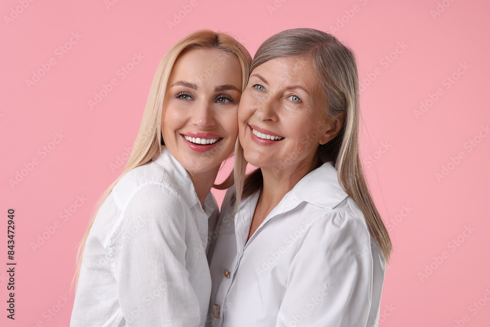 Family portrait of young woman and her mother on pink background Family portrait of young woman and her mother on pink background