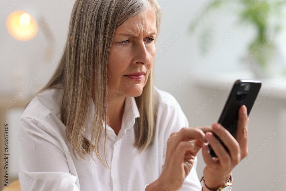 Senior woman using mobile phone at home Senior woman using mobile phone at home