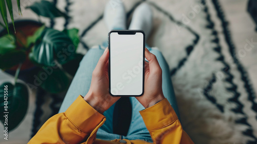 Mockup woman's hand holding using smart phone with white blank screen POV  at coffee shop, mobile app design and advertising, online marketing photo