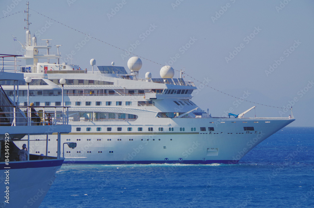 Naklejka premium Classic ocean cruiseship cruise ship liner Nefeli in port of Rhodes City, Greece with panoramic oceanscape sea views and other passenger vessels in harbor