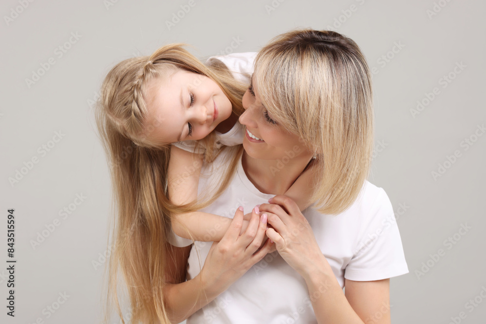 Family portrait of happy mother and daughter on grey background Family portrait of happy mother and daughter on grey background