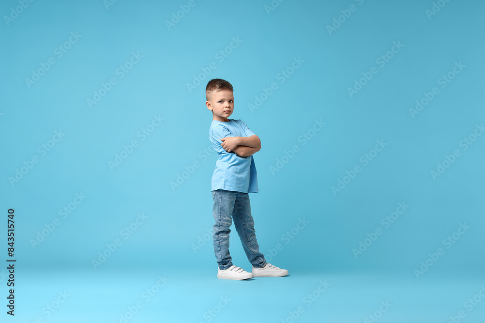Happy little boy dancing on light blue background Happy little boy dancing on light blue background