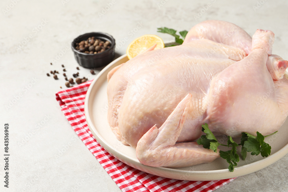 Fresh raw chicken with spices and lemon on light grey table Fresh raw chicken with spices and lemon on light grey table