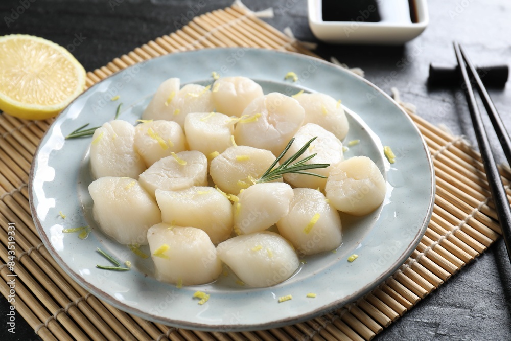 Raw scallops with lemon and rosemary on dark textured table, closeup Raw scallops with lemon and rosemary on dark textured table, closeup