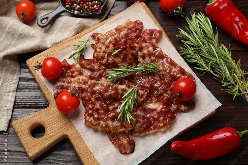 Slices of tasty fried bacon, tomatoes and different spices on wooden table, top view Slices of tasty fried bacon, tomatoes and different spices on wooden table, top view