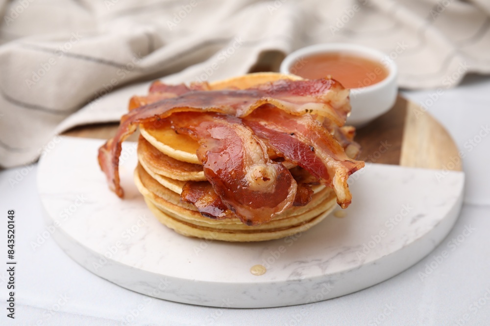 Delicious pancakes with bacon and honey on white table, closeup Delicious pancakes with bacon and honey on white table, closeup