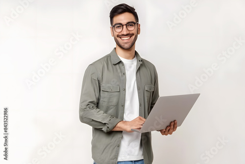 Portrait of young modern businessman standing holding laptop isolated on white background