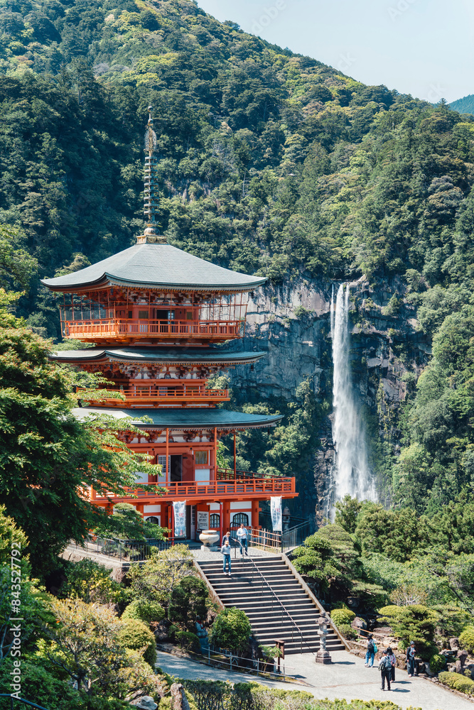 The red three-story pagoda of Seigantoji Buddhist Temple in front of Nachi Falls. Beautiful natural scenery in Nachikatsuura, Japan The red three-story pagoda of Seigantoji Buddhist Temple in front of Nachi Falls. Beautiful natural scenery in Nachikatsuura, Japan