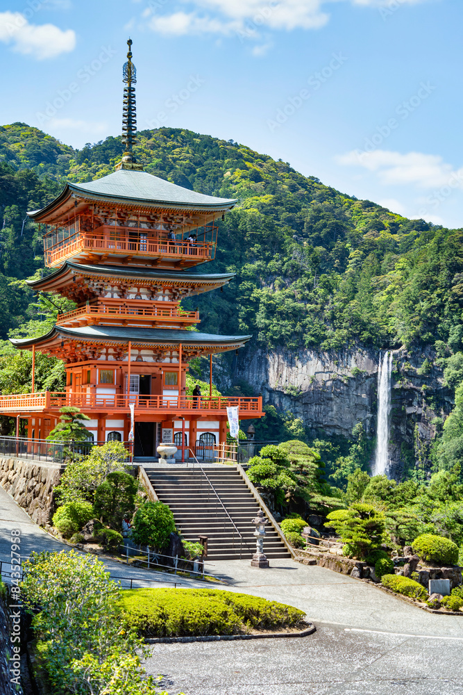 The red three-story pagoda of Seigantoji Buddhist Temple in front of Nachi Falls. Beautiful natural scenery in Nachikatsuura, Japan The red three-story pagoda of Seigantoji Buddhist Temple in front of Nachi Falls. Beautiful natural scenery in Nachikatsuura, Japan