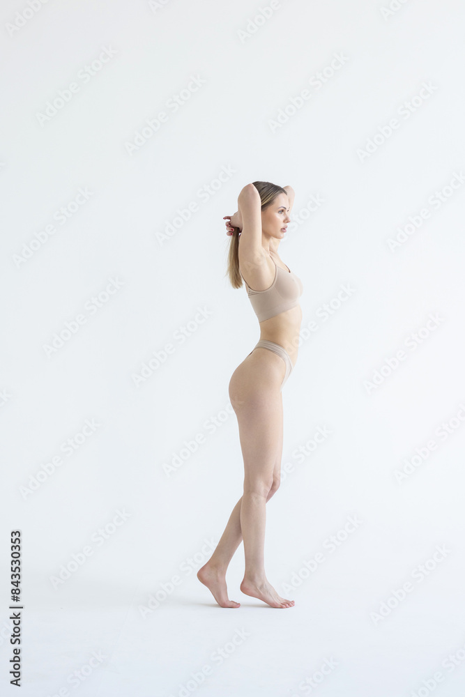 Naklejka premium Perfect body shape. Full-length portrait of woman with slim fit figure in gray inner wear posing on grey background.
