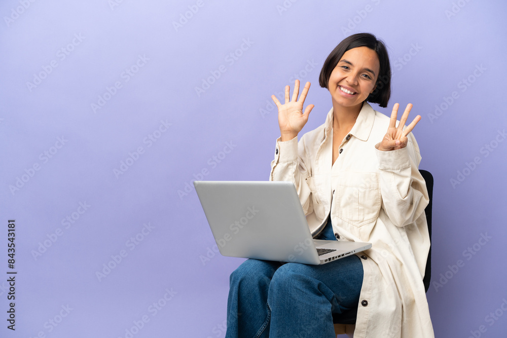Young mixed race woman sitting on a chair with laptop isolated on purple background counting eight with fingers Young mixed race woman sitting on a chair with laptop isolated on purple background counting eight with fingers