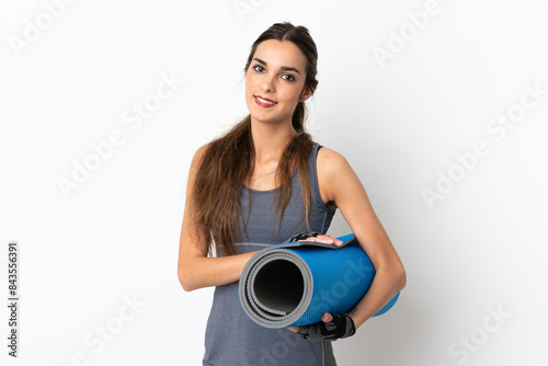 Young caucasian woman isolated on white background with a mat and smiling