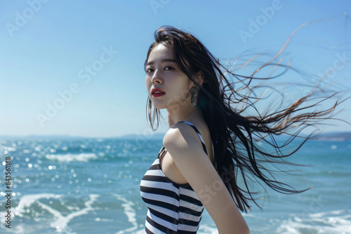 a woman in a striped dress standing on a beach © WapTock