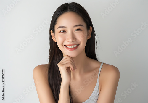 photo of Japanese beauty model her thirty long straight hair fair skin tone smiling while touching her chin one hand She no makeup her face creating overall clean look against white background woman