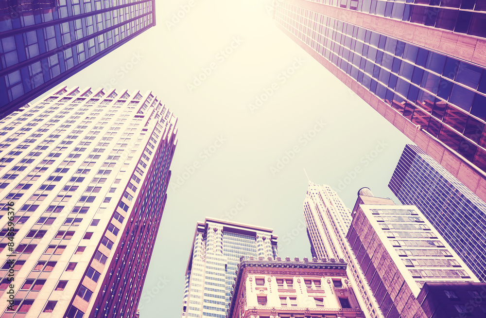 Looking up at New York City skyscrapers against the sun, color toning applied, USA. Looking up at New York City skyscrapers against the sun, color toning applied, USA.