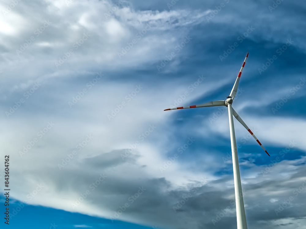 Wind Turbine In Front Of Blue Sky With Heavy Clouds Wind Turbine In Front Of Blue Sky With Heavy Clouds