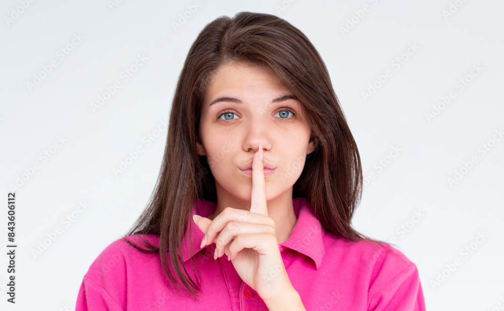 Shhh sign. Young woman showing shh gesture to keep a silent. Girl in template pink t shirt keep a secret. Quiet place and silence time Shhh sign. Young woman showing shh gesture to keep a silent. Girl in template pink t shirt keep a secret. Quiet place and silence time