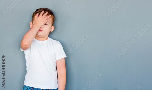 childhood, expressions and people concept - sick boy in white t-shirt suffering from headache over grey background