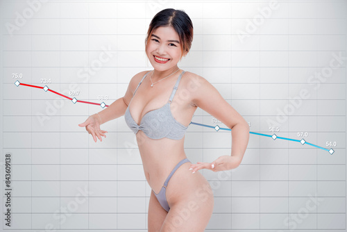 Happy asian woman in underwear with line chart at back tracking progress of weight loss over time. photo