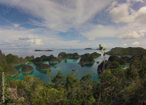 Scenic viewpoint tropical limestone islands covered in vegetation of Pianemo in Raja Ampat district of Indonesia photo