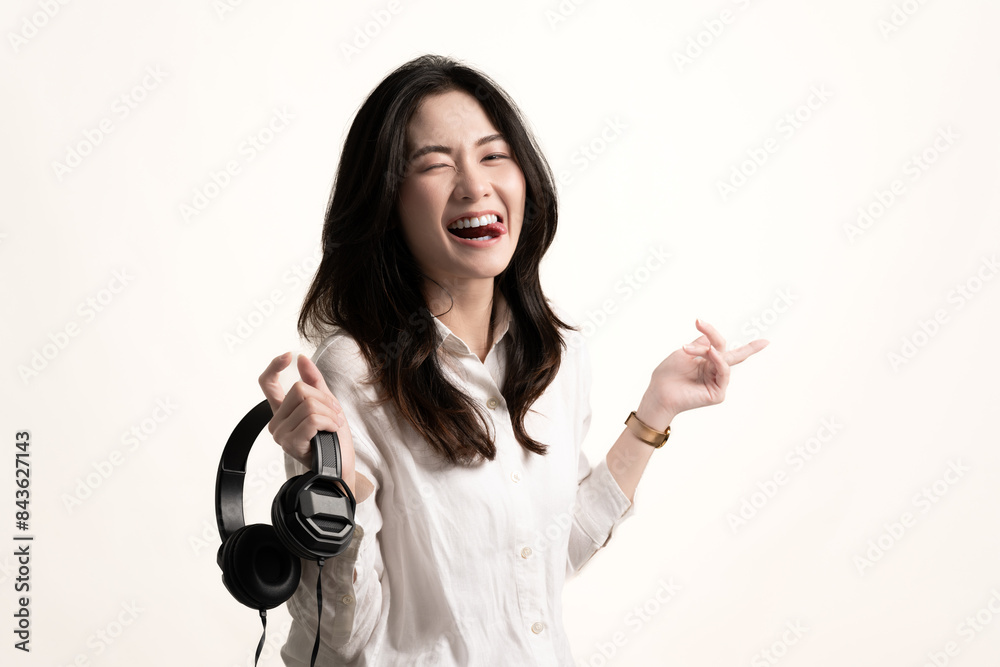 Portrait young happy asian woman wear white shirt and headphones listen to music with smile have fun isolated on white background.Beautiful girl smiling and funny listen music at home.Life style Portrait young happy asian woman wear white shirt and headphones listen to music with smile have fun isolated on white background.Beautiful girl smiling and funny listen music at home.Life style