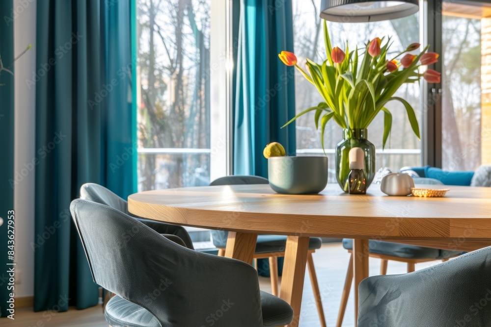 Wooden Dining Table With Teal Chairs and a Bouquet of Tulips in a Vase