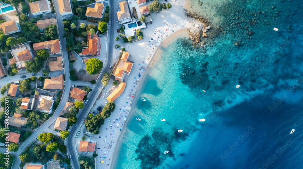 Aerial view of a quaint seaside town with sandy beaches and blue waters 