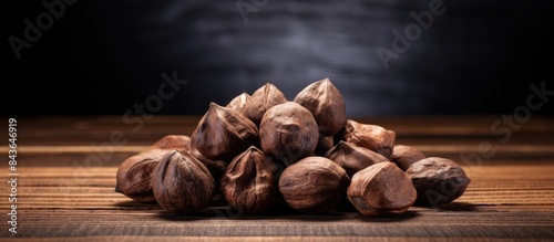 A close up copy space image of whole dried Cola Nuts placed on a wooden background photo