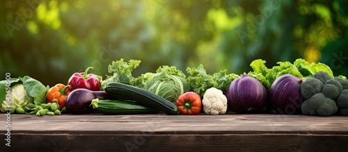 Panel kuchenny z motywem A variety of fresh vegetables like cabbage lettuce eggplant zucchini and green slate arranged on a picnic table with a copy space image