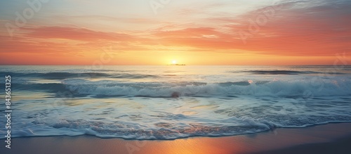 A captivating copy space image of sunset over the beach with frothy waves gracefully rolling onto the shore