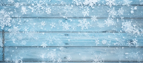 Frame of white snow on light blue wooden background top view with space for text Christmas season. copy space available