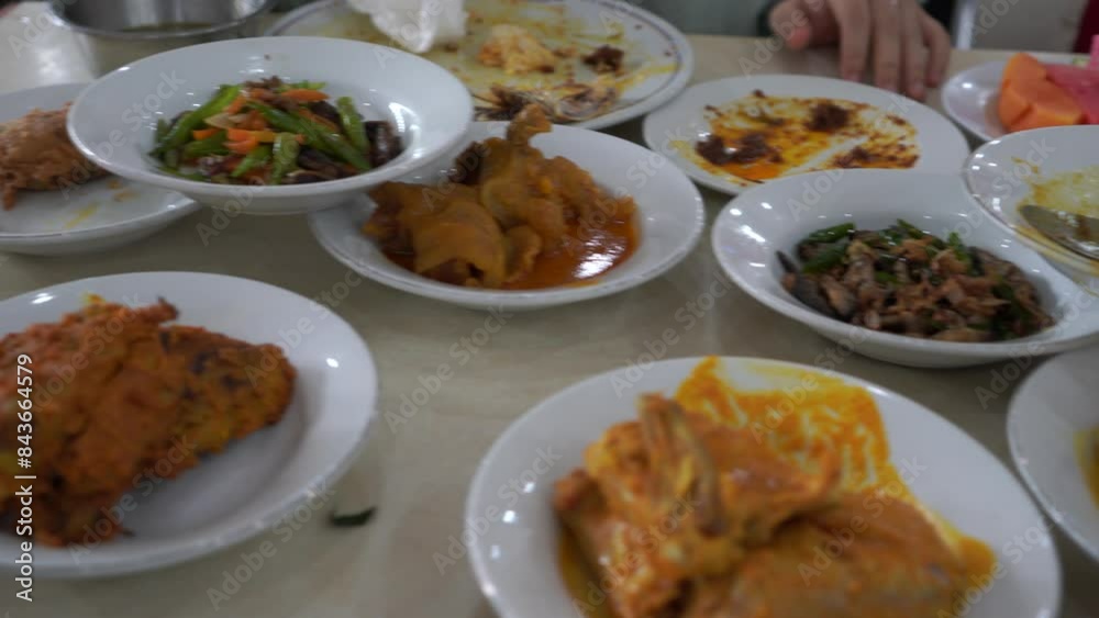 Various menus on white plates from a Padang cuisine restaurant consisting of potato fried chili sauce, eggplant chili sauce, green chili sauce arranged in neat pile table. Minang or Minangkabau food. Various menus on white plates from a Padang cuisine restaurant consisting of potato fried chili sauce, eggplant chili sauce, green chili sauce arranged in neat pile table. Minang or Minangkabau food.