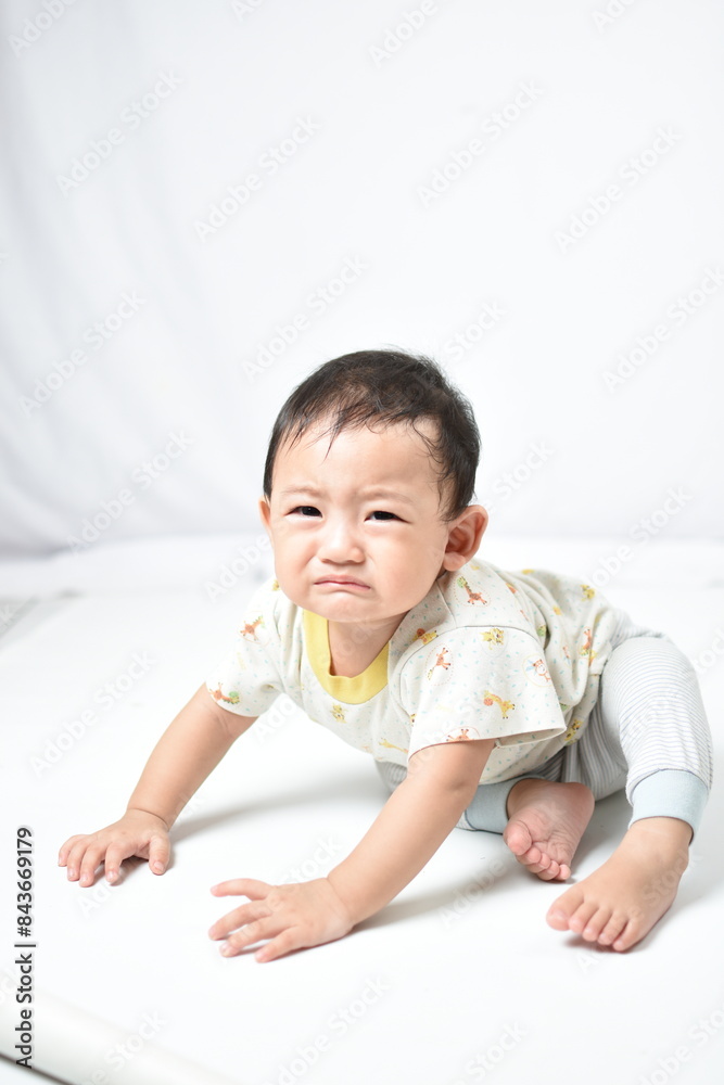 Adorable baby crawling on a white background with a slightly upset expression, furrowing brows and puckering lips. Capturing a moment of babyhood with a mix of curiosity and frustration Adorable baby crawling on a white background with a slightly upset expression, furrowing brows and puckering lips. Capturing a moment of babyhood with a mix of curiosity and frustration