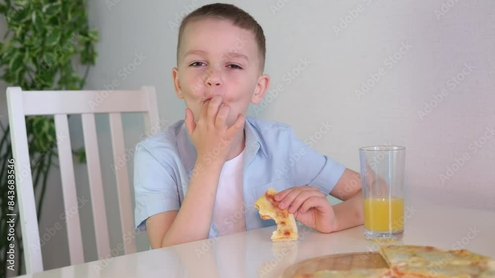 Happy little boy enjoying lunch eating a piece of pizza at home in the kitchen. Children love junk food. Baby food concept. Selective focus.
Happy little boy enjoying lunch eating a piece of pizza at home in the kitchen. Children love junk food. Baby food concept. Selective focus.