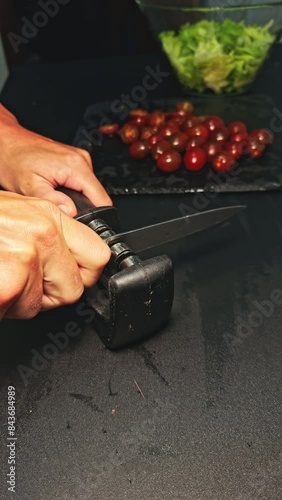 Sharpening knife with tomatoes close-up