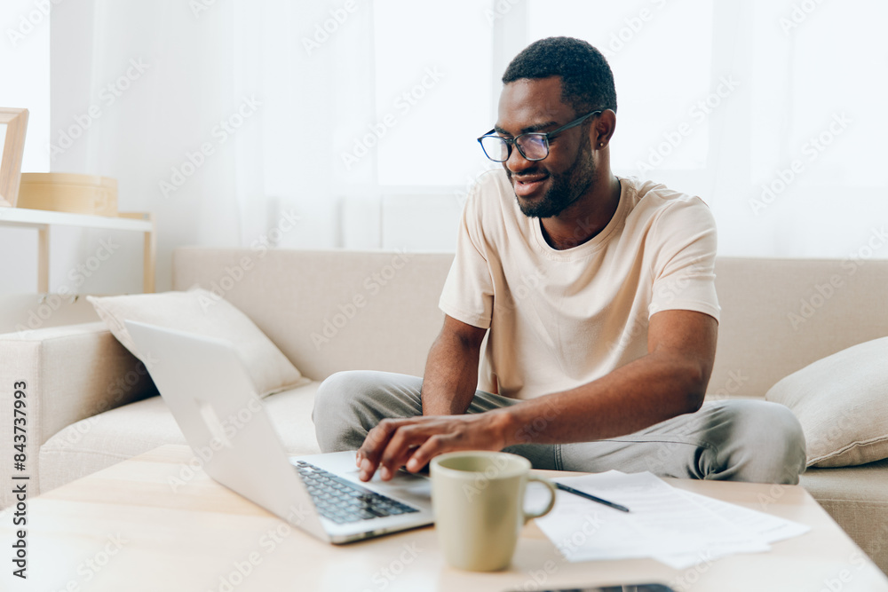 Smiling African American Freelancer Typing on Laptop in Modern Home Office Smiling African American Freelancer Typing on Laptop in Modern Home Office