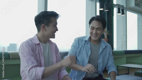 Young Business man discussing work in the co-working space. Business people Excited over a successful project in Co-Working space.