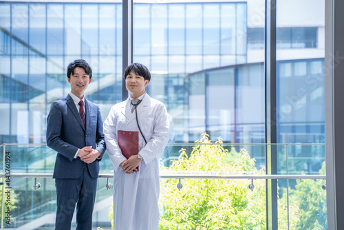 病院で打合せをする医師とビジネスマン