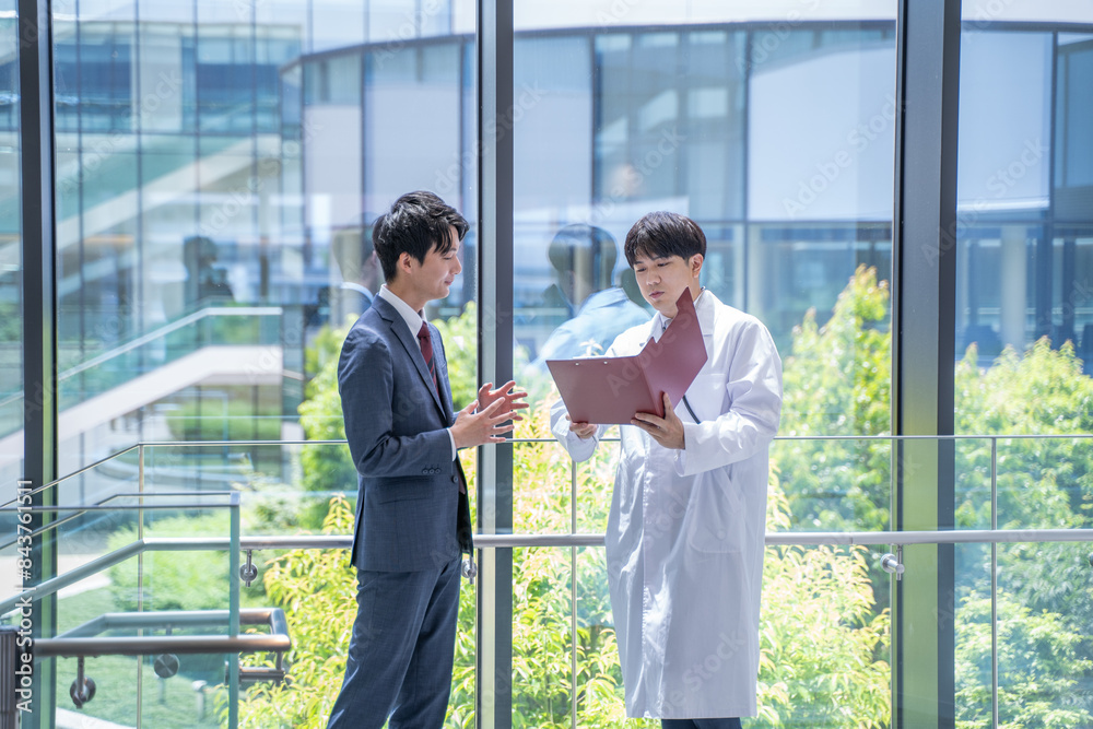 病院で打合せをする医師とビジネスマン 病院で打合せをする医師とビジネスマン